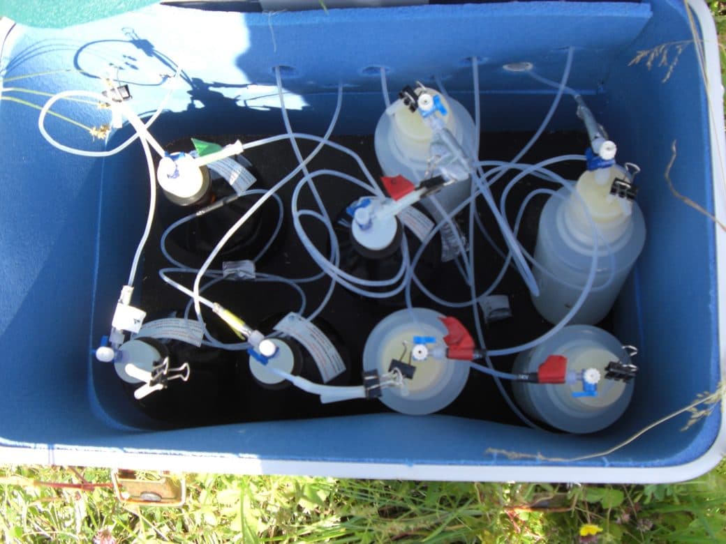 Picture: The photo shows a box photographed from above, in which several suction candle bottles are located. Thin tubes lead through openings in the box from outside, which are attached to the tops of the bottles.